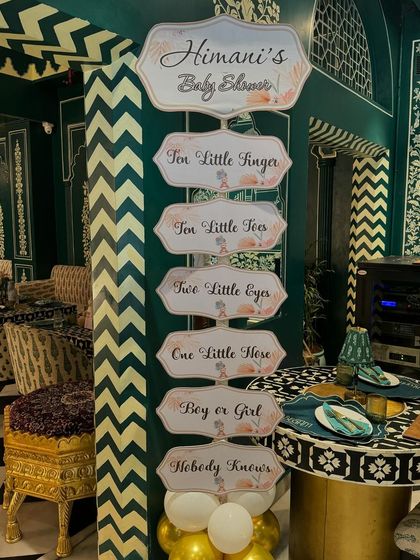 A decorative signpost with a sweet poem: 'Ten little fingers, ten little toes... Boy or girl, nobody knows.' This adds a touch of charm and anticipation to the decor.
