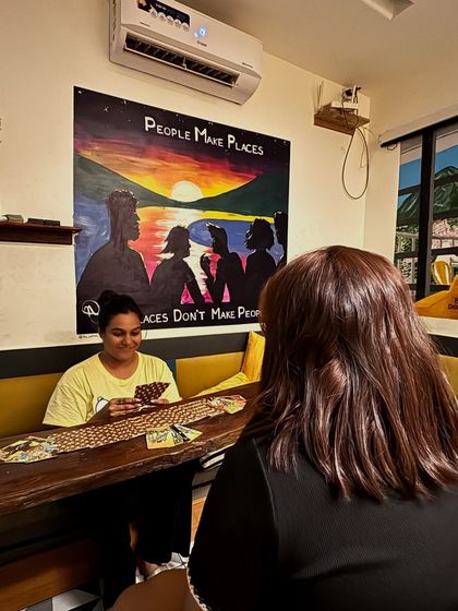 A candid shot of a reading in progress. The artwork behind me says "People Make Places," which is a belief I hold close to my heart. It's the connection between people that truly creates the magic.