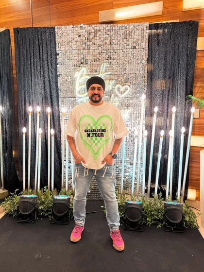 Standing in front of the photo booth at a 25th-anniversary party. The decor was on point.