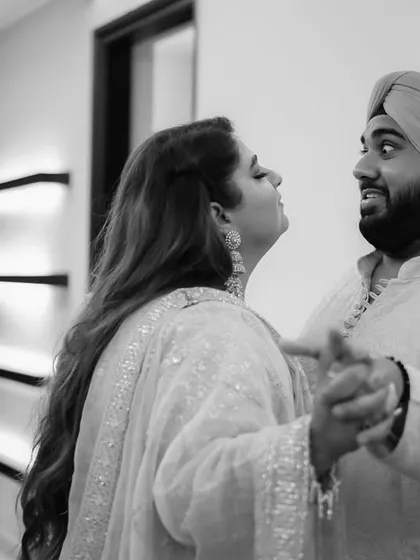 A fun, candid dance move between the couple. Black and white enhances the sense of movement and their playful energy.