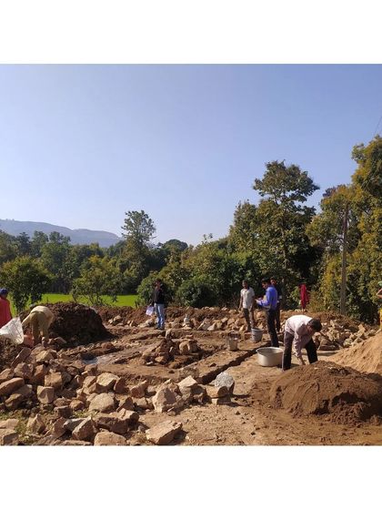 A wide view of the bustling construction site for an MP Homestay, with the community actively involved in every step. This project, in partnership with the MP Tourism Board, aims to create economic opportunities through community-based tourism.