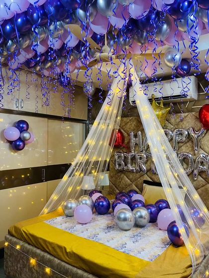 This angle highlights the beautiful cascade of purple and silver balloons from the ceiling, complete with swirling ribbons.