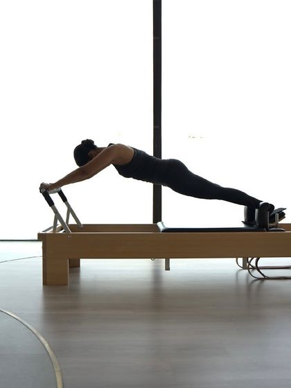 The plank on the Reformer is a powerful exercise for building total body strength. It requires immense core control and stability, a cornerstone of the Classical Pilates method.