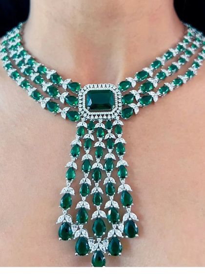 A magnificent, cascading necklace with green stones and American Diamonds. This is a high-end designer piece, perfect for a very formal event or a red carpet look.