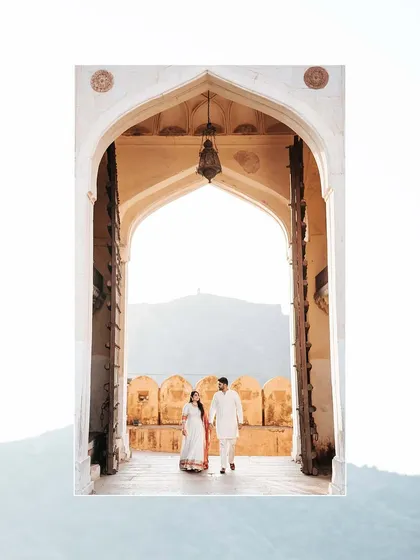 A beautiful silhouette of the couple walking through a grand fort entrance, symbolizing the start of their new journey together.