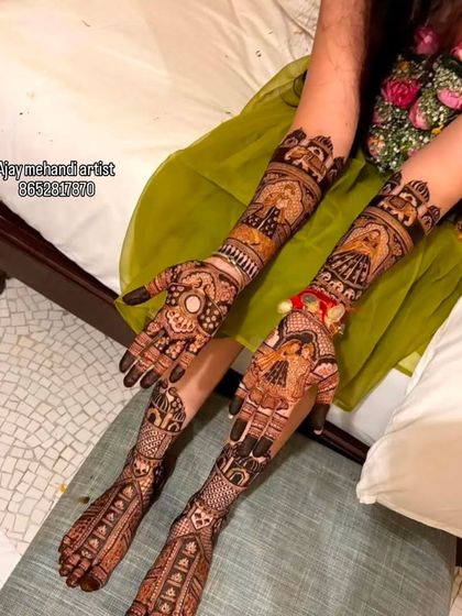 A candid shot of a bride relaxing with her full bridal mehndi. The designs extend up her arms and legs, creating a stunning visual.
