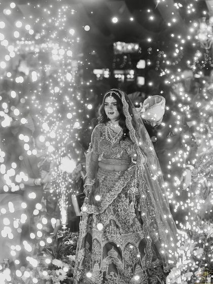 A magical black and white photo of the bride's entrance, surrounded by a tunnel of fairy lights and cold pyro, creating a truly cinematic moment.
