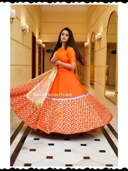 The talented Chaitra Vasudevan looking radiant in a custom orange lehenga I designed. This twirling shot captures the beautiful flare of the Benarasi brocade skirt, perfect for any festive occasion or celebration.