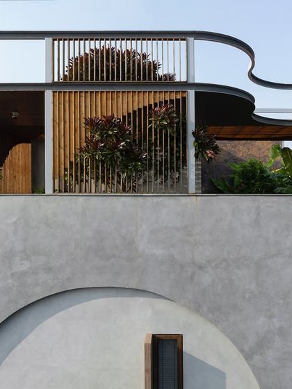 The curved facade of a rooftop structure, with planters and wooden screens creating a soft, organic feel. The landscape design here becomes an integral part of the building's architectural expression.