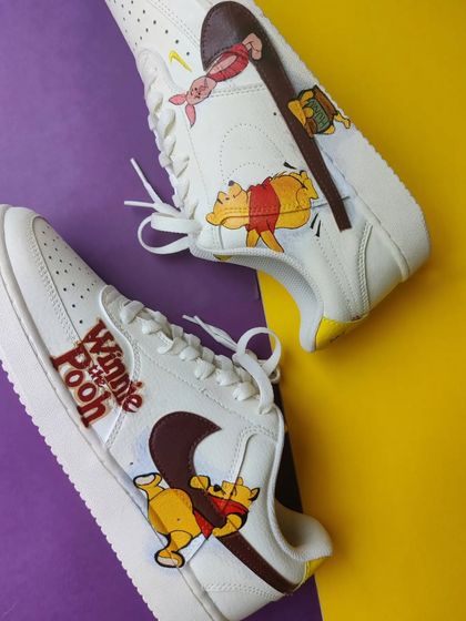 A top-down view of the Winnie the Pooh custom Nike Court Visions.