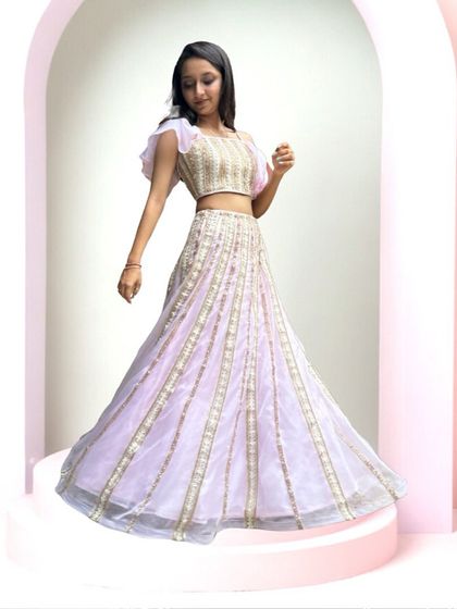 A full view of our pink statement lehenga. The light organza fabric and modern silhouette make it a fun and fashionable choice for any wedding event.