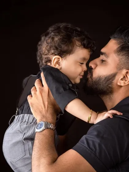 A tender black and white photo of a father and son, nose to nose.