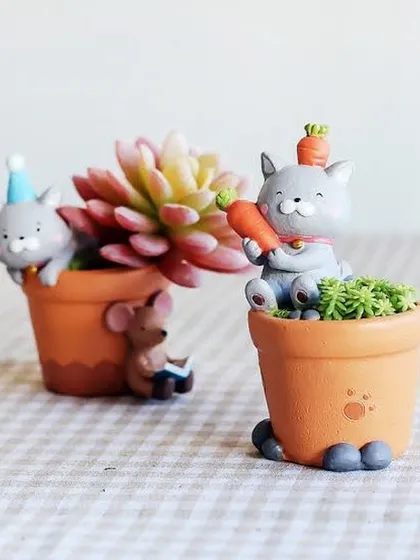 These cute cat-themed resin pots are perfect for tiny succulents. One design features a cat with a carrot, adding a playful and imaginative touch to your plant display.