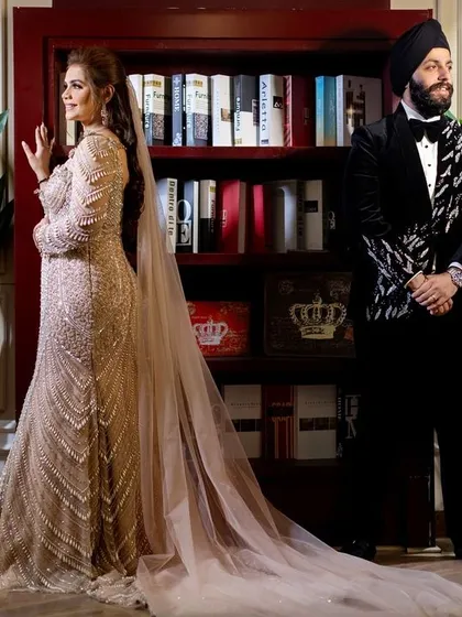 A stylish, posed shot of the couple in front of a modern library setting, showcasing their sophisticated style and the unique backdrops we find for portraits.