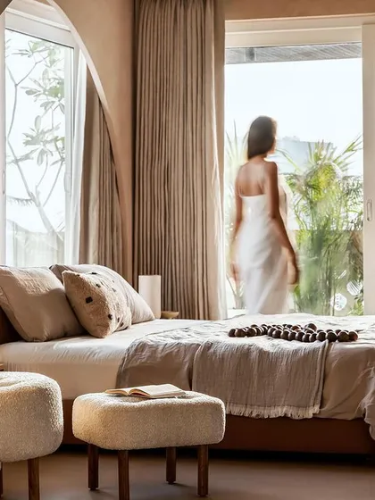 A serene bedroom in our "Marshmallow" project, where arched windows and soft, neutral tones create a tranquil haven. The custom wallpapered column adds a unique artistic touch.