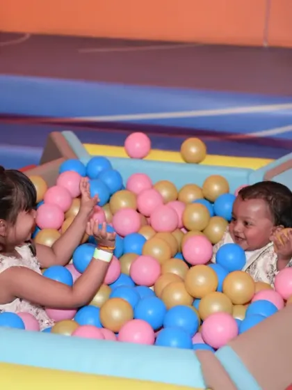 Siblings sharing a playful moment in the ball pit. Our playzone is perfect for kids of different ages to have fun together.
