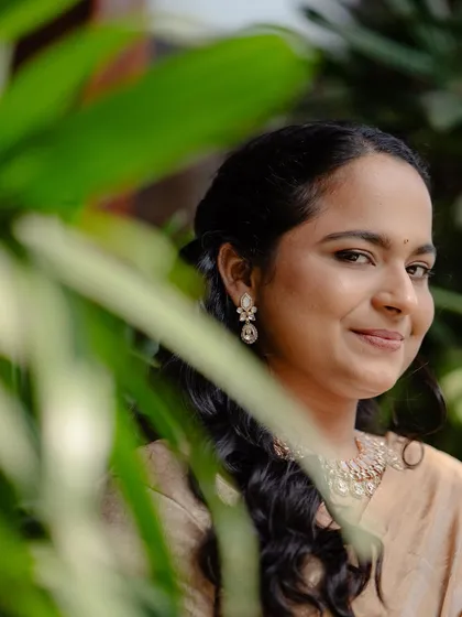 A beautiful portrait of the bride, framed by greenery. Her simple makeup and loose waves look effortlessly elegant.