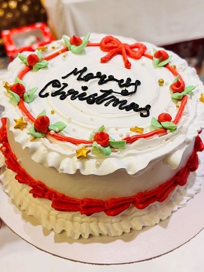 This vintage-style Merry Christmas cake is decorated with classic red and white buttercream frills, delicate roses, and green leaves. It’s a festive centerpiece for any holiday gathering.