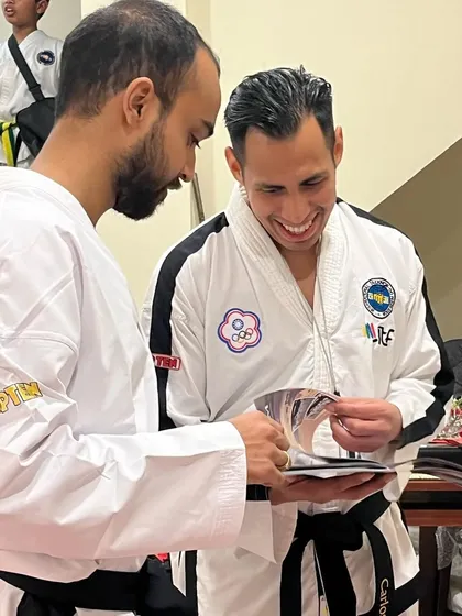A candid photo of Sabum Carlos Machado smiling as he looks through the magazine.