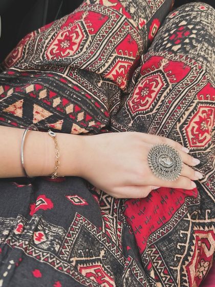 A close-up shot of my hand, showcasing a statement silver ring and bracelet, paired with the intricate pattern of my ethnic trousers. It’s all in the details.