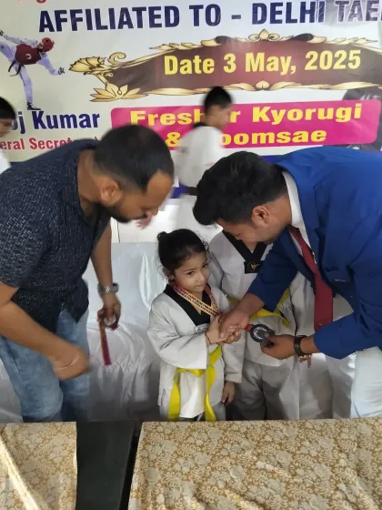 A heartwarming moment as one of our youngest students receives her medal at a district event. We welcome and train children of all ages.