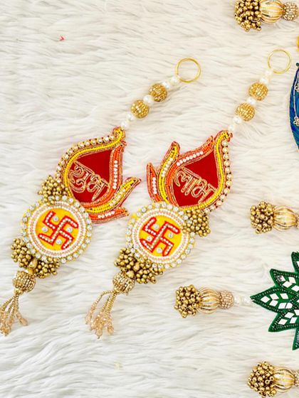 A close-up of the diya-shaped Shubh Labh hangings with swastika symbols. These are perfect for pairing with a bandhanwar or hanging in your mandir.