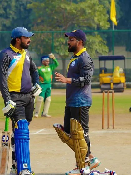 Discussing strategy with a teammate between overs. Just like in a legal case, communication and a clear plan are essential for success on the cricket pitch.