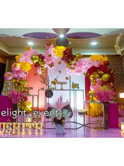 A beautiful butterfly garden theme for a first birthday celebration. This decor uses a soft pink and yellow balloon arch accented with delicate butterfly cutouts, a light-up number '1', and modern stands for a sweet and elegant party.