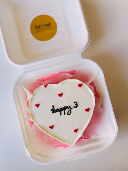 A cute heart-shaped bento cake to celebrate a third anniversary or birthday, with "happy 3" written in clean black script.