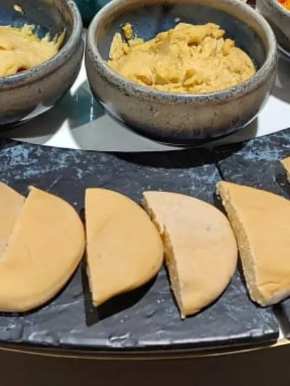 A close-up of the hummus and pita bread from the ALSORG corporate event. I offer a variety of flavors, including classic and peri-peri, to cater to different tastes.