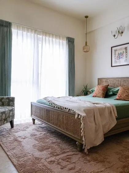 In this master bedroom from our 'Earthy Chic' project, we created a calm oasis using natural textures like wood and rattan. We also reupholstered the client's classic wing chair in a vibrant fabric, demonstrating our ability to integrate and give new life to cherished personal items within a new design scheme.