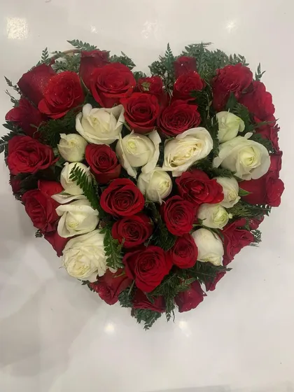 Another look at the red and white rose heart arrangement, showing the careful placement of each flower to create the perfect shape.