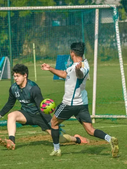 A striker shoots on goal as the goalkeeper dives to make a save. This is the kind of decisive, goal-mouth action you can expect in our leagues.