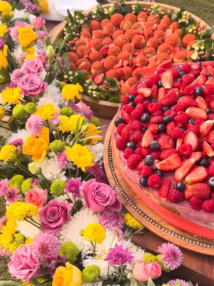 A beautiful dessert table I created for a special celebration, surrounded by fresh flowers. I love making your events beautiful and delicious with treats like my berry-topped cakes and fresh strawberry choux pastries.