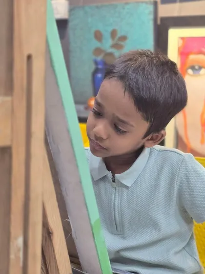 A young artist completely absorbed in his work, demonstrating incredible focus as he creates a detailed animal drawing with a ballpoint pen.