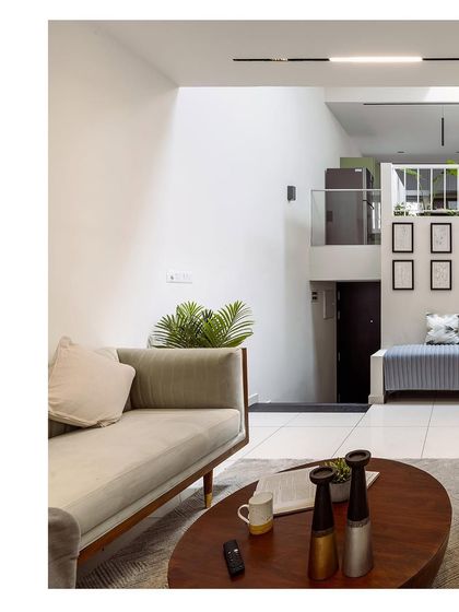 A wide shot of the living room, showing the relationship between the sofa, coffee table, and the staircase in the background. This image helps to understand the overall layout of the space.