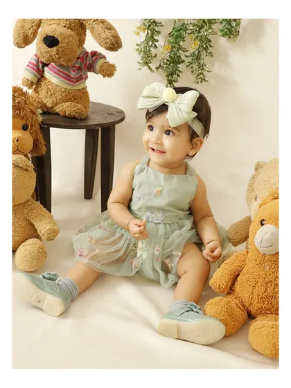 A happy baby surrounded by her favorite teddy bears. I use simple, classic props to create a comfortable and playful environment for your little one's milestone photoshoot.