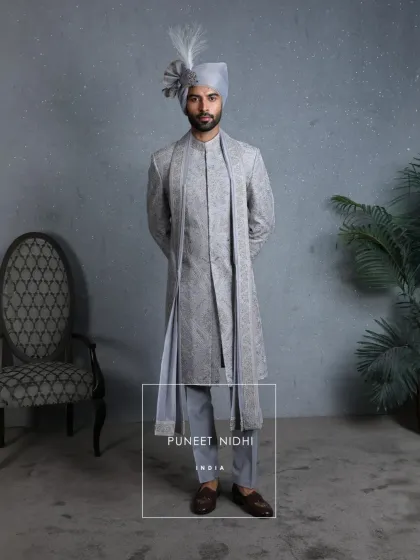 The complete powder blue sherwani ensemble, with a matching stole, showcases fine handwoven detailing, sequins, and threadwork that breathe life into tradition.