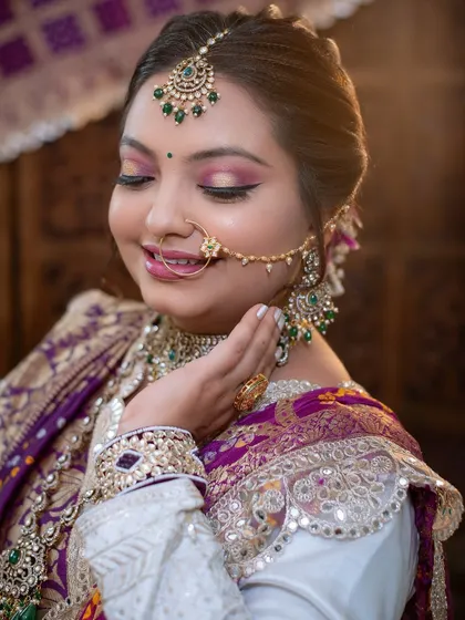 The soft lighting enhances the glow of her skin and the richness of her traditional outfit.