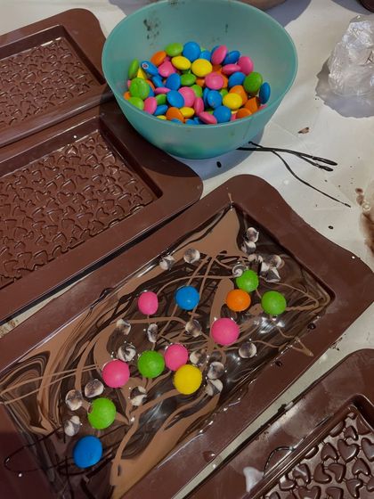 The DIY chocolate making station is always a huge hit. Kids get to pour melted chocolate and decorate their bars with colorful gems and sprinkles. It's a delicious and creative activity.