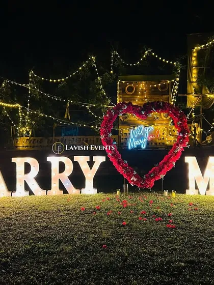 You only get one shot to ask the big question, and I make sure the setting is perfect. This classic lawn setup features large marquee letters, string lights, and a rose petal pathway for an undeniably romantic proposal.