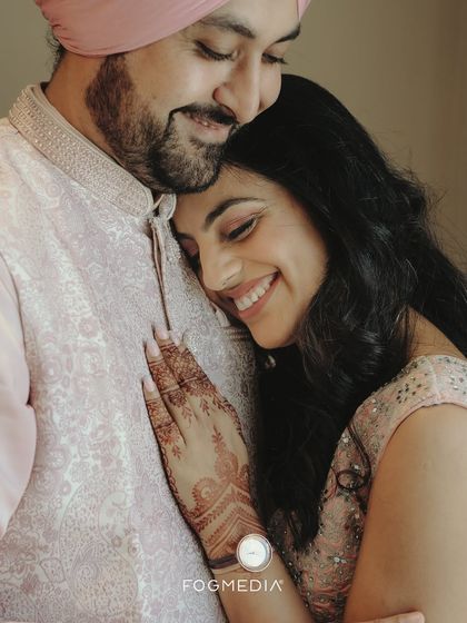 An intimate close-up showing the bride's intricate henna and the couple's gentle embrace. This photo highlights the beautiful details and quiet emotions of a traditional celebration.