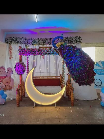 Another view of the lit-up baby shower decor in the outdoor space, showcasing the vibrant blue peacock.
