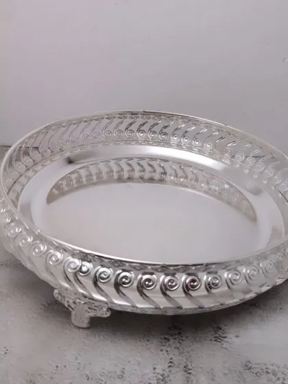 A German silver tray with a beautiful spiral-patterned border and three small legs, adding to its decorative appeal.