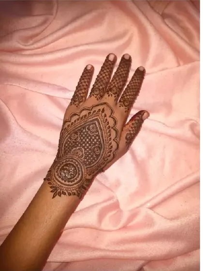 A lovely heart-shaped mandala design on the palm, filled with intricate net-like details. A very popular choice for festive occasions.