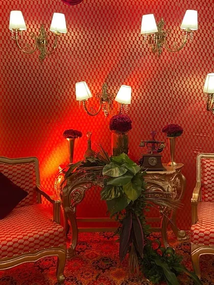 A vintage-inspired photo corner for an engagement party. I used ornate gold-framed furniture, classic wall lamps, and a rich red textured backdrop to create this elegant vignette.