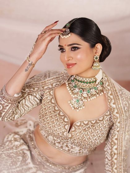 A confident and glamorous portrait of the bride, showcasing her stunning jewelry and the elegant updo that completes the look.