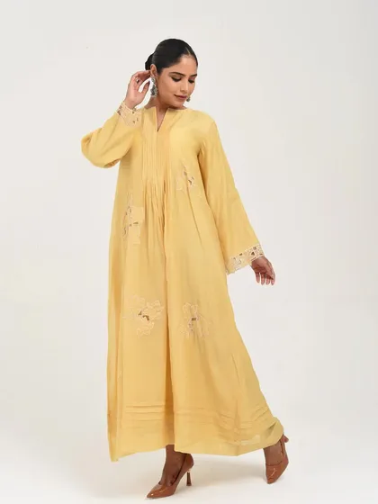 A beautiful pastel yellow dress with lace-insert details and a relaxed, flowing silhouette.