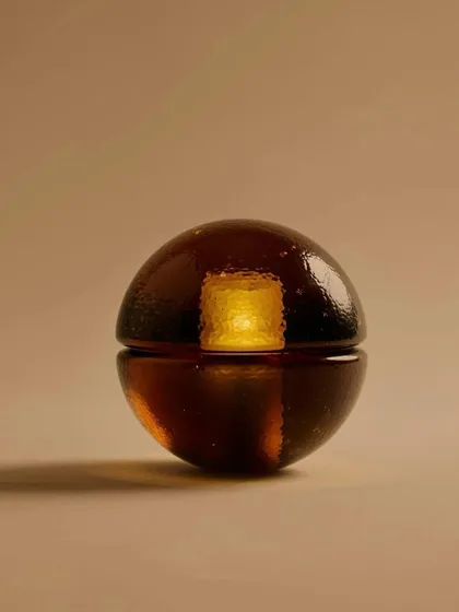 A close-up of the Bocci 14p in a rich sepia color, showcasing its warm, candle-like glow.