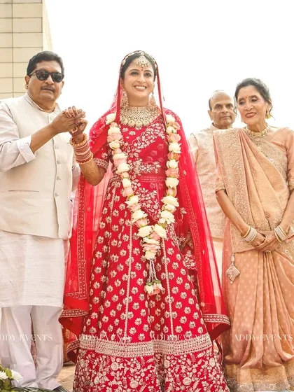 A precious family moment, as the bride holds her father's hand while her family looks on with love and pride.